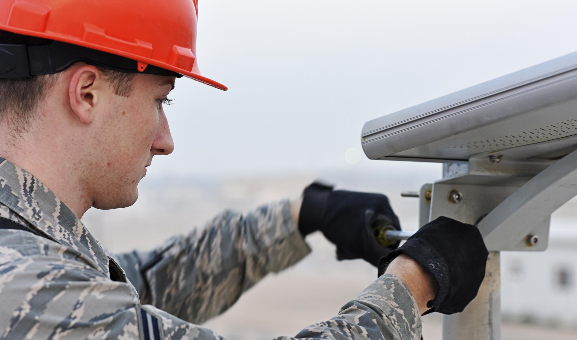 U.S. Air Force Airman 1st Class Corey Martin, an electrical systems apprentice with the 379th Expeditionary Civil Engineer Squadron, adjusts a light fixture at Al Udeid Air Base, Qatar, Feb. 22, 2017. Airmen with the 379th ECES Electrical Systems Section maintain 67 solar-powered low-emitting diode lights in Coalition Compound, the living area side of Al Udeid, in an effort to save on utility costs. (U.S. Air Force photo by Senior Airman Cynthia A. Innocenti)