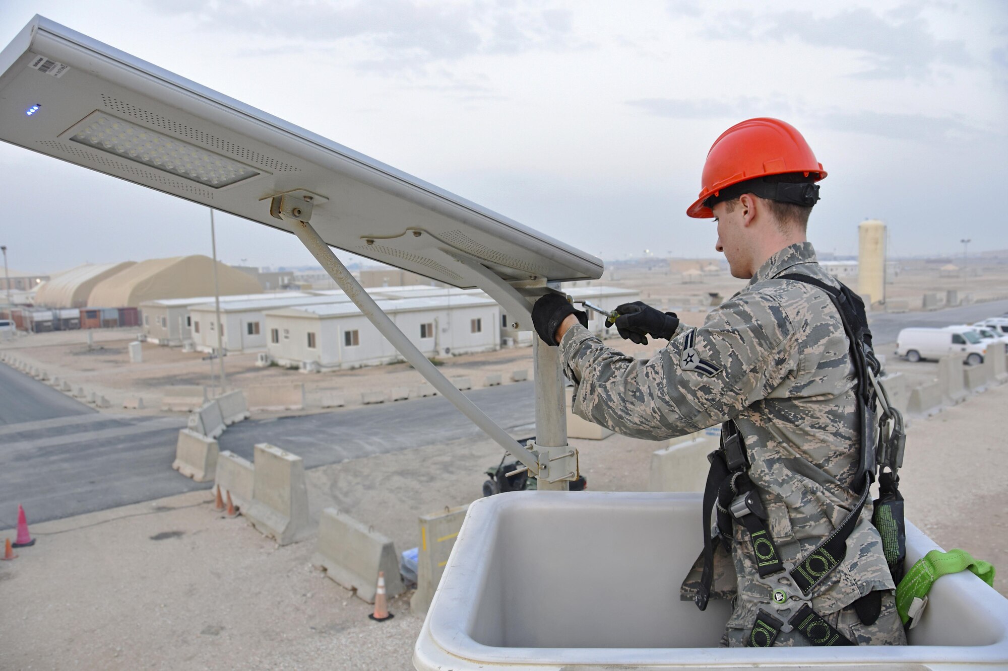 U.S. Air Force Airman 1st Class Corey Martin, an electrical systems apprentice with the 379th Expeditionary Civil Engineer Squadron, adjusts a light fixture at Al Udeid Air Base, Qatar, Feb. 22, 2017. Airmen with the 379th ECES Electrical Systems Section maintain 67 solar-powered low-emitting diode lights in Coalition Compound, the living area side of Al Udeid, in an effort to save on utility costs. (U.S. Air Force photo by Senior Airman Cynthia A. Innocenti)