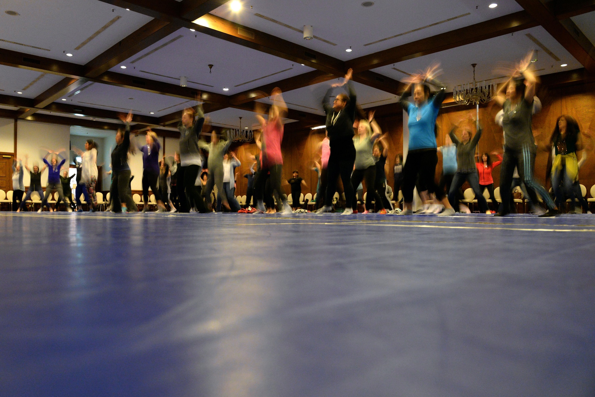 Military spouses engage in physical activities performing jumping jacks. A SpouseFit event took
place Feb. 22 and 23 on Ramstein. (Photo by Airman 1st Class D. Blake Browning)