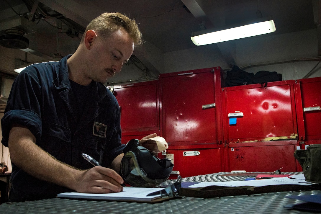 Navy Seaman Garrett Bowes inspects an MCU-2P gas mask on the aircraft carrier USS Carl Vinson in the Philippine Sea, Feb. 15, 2017. Bowes is a damage controlman fireman. Navy photo by Petty Officer 3rd Class Matt Brown