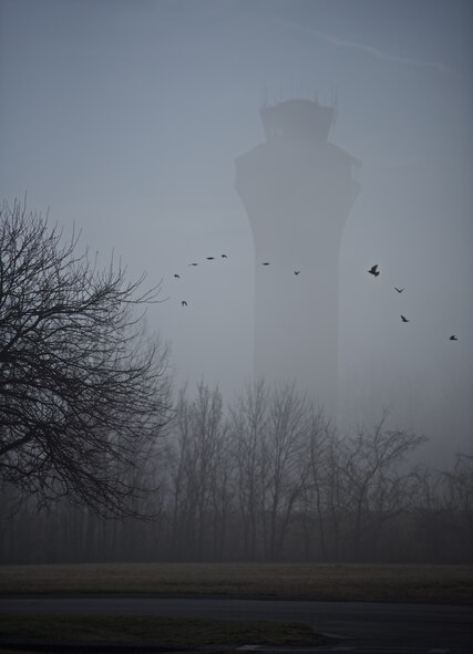 Birds take flight in the early morning fog at Scott Air Force Base, Illinois, Feb. 23, 2017.   The air traffic tower, veiled in mist, is barely visible as the fog gives way to the sunrise. (U.S. Air Force photo by Christopher Parr)