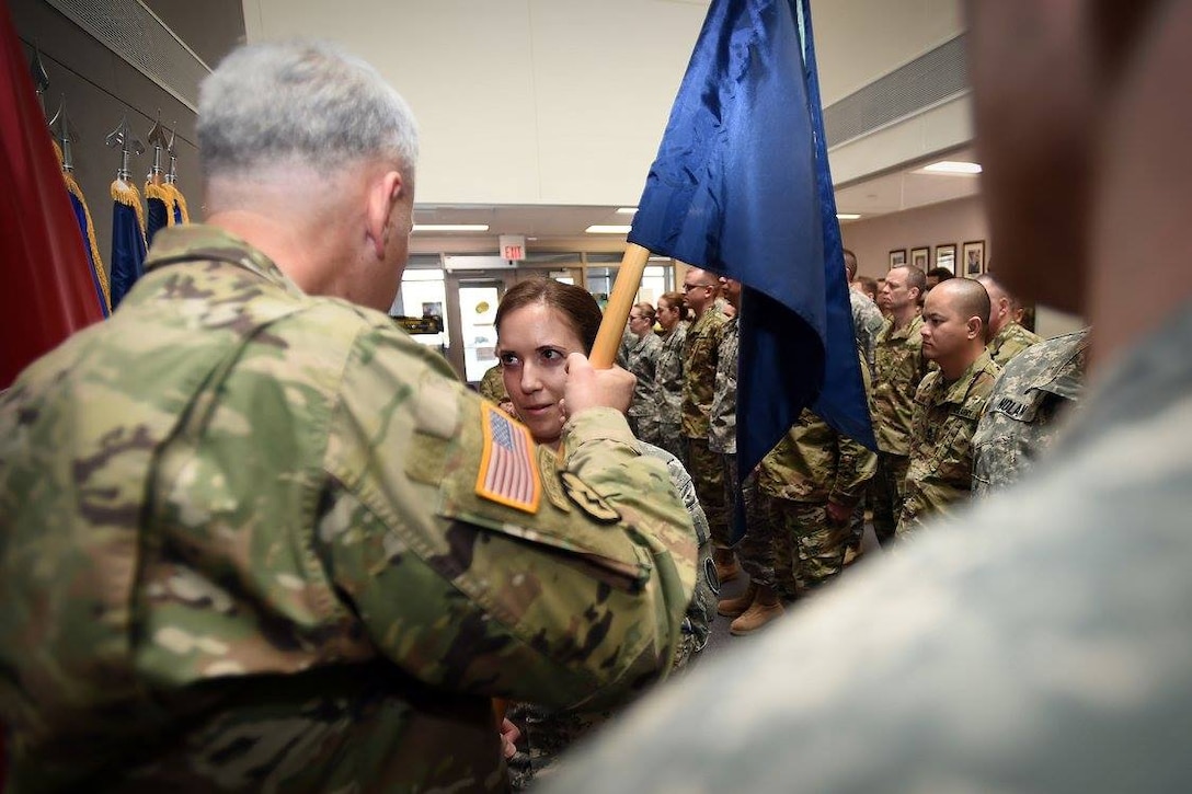 Army Reserve Capt. Rebecca Spohr, center, Headquarters and Headquarters Company Commander, 85th Support Command, takes the company guidon from Col. Robert Cooley, Deputy Commanding Officer, 85th Support Command, during the command's HHC Change of Command ceremony, Feb. 12, 2017.
(Photo by Sgt. Aaron Berogan)