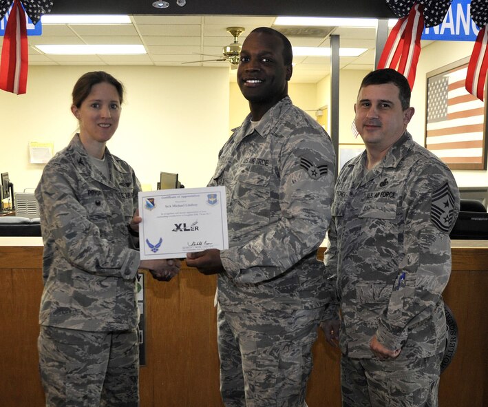 Senior Airman Michael Lindsay, 47th Force Support Squadron reenlistments and extensions technician (center), accepts the “XLer of the Week” award from Col. Michelle Pryor, 47th Flying Training Wing vice commander (left), and Chief Master Sgt. George Richey, 47th FTW command chief (right), on Laughlin Air Force Base, Texas, Feb. 15, 2017. The XLer is a weekly award chosen by wing leadership and is presented to those who consistently make outstanding contributions to their unit and Laughlin. (U.S. Air Force photo/Technical Sgt. Mike Meares)