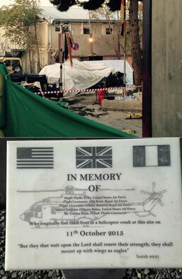 (Top) A tarp covers the mangled British Puma MK2 helicopter at the site of the crash on the compound of Camp Resolute Support in Kabul, Afghanistan, in the days following the Oct. 11, 2015, crash. (Below) Today, a plaque sits at the crash site honoring the memory of the five NATO service members killed. 