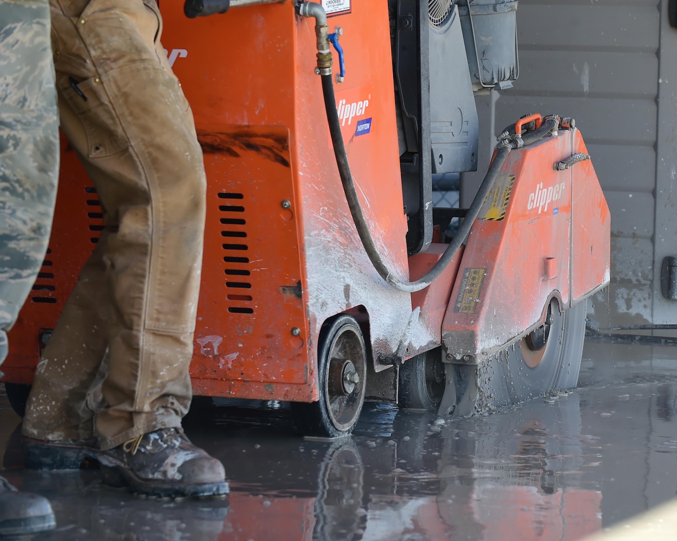 460th Civil Engineering Squadron heavy equipment operators use a concrete saw to cut through pavement Feb. 17, 2017 on Buckley Air Force Base, Colo. Concrete cutting is one of the first steps in the process of repairing a pipe leak. (U.S. Air Force photo by Airman 1st Class Jessica A. Huggins/Released)