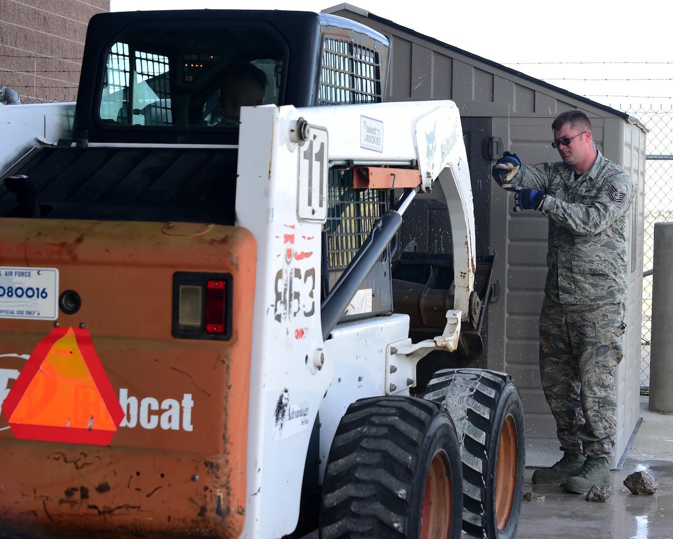 Tech. Sgt. Zachary Long, 460th Civil Engineering Squadron heavy equipment section NCO in Charge, assists an Airman bringing in machinery through the use of hand signals Feb. 17, 2017 on Buckley Air Force Base, Colo. The Airmen in this section are trained to handle various types of heavy equipment. (U.S. Air Force photo by Airman 1st Class Jessica A. Huggins/Released)