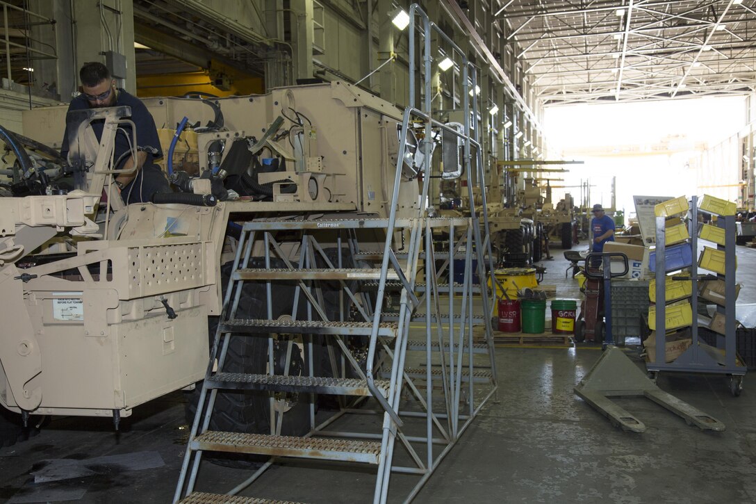 Teodoro Huerta, a former Army staff sergeant who has been deployed to the Middle East, is a heavy mobile equipment mechanic on the LVSR AMKR line at Production Plant Barstow, Marine Depot Maintenance Command. He is installing hydraulic lines on the AMKR at the plant, Feb. 14.