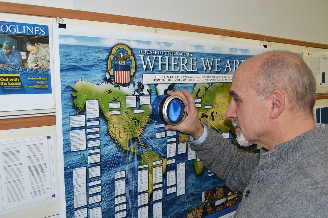 Joe Yoswa uses an oversize printers loop to examine details on an insert for Loglines.