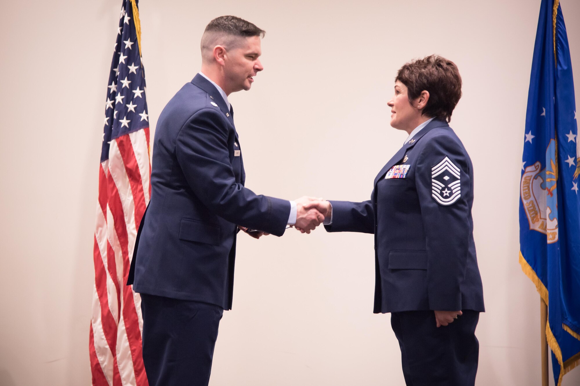 Lt. Col. Quinten Sasnett, 403rd Maintenance Squadron commander shakes the hand of Chief Master Sgt. Michelle Santiago, 403rd MXS first sergeant, during her promotion ceremony Feb. 11 at Keesler Air Force Base, Mississippi.(U.S. Air Force photo/Staff Sgt. Heather Heiney)