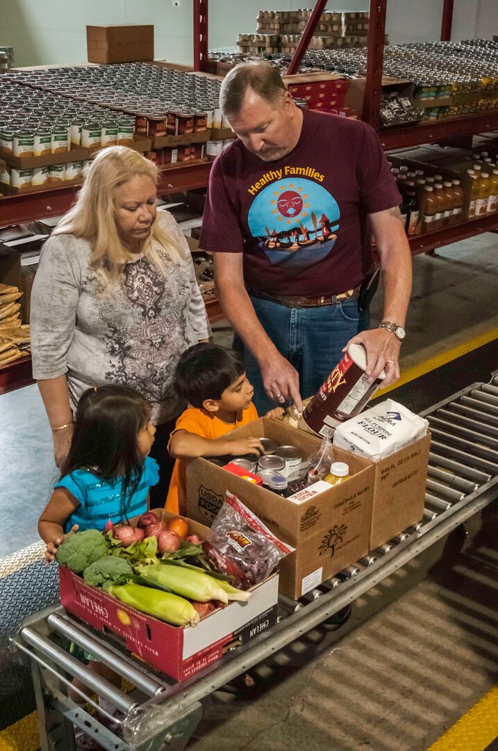 Michael and Jo Maxwell and their children Darcilena and Santiago Jansen receive fresh fruits and vegetables provided through DLA contracts, along with other foods, through the Food Distribution Program on Indian Reservations of the Small Tribes of Western Washington in Lakewood. 