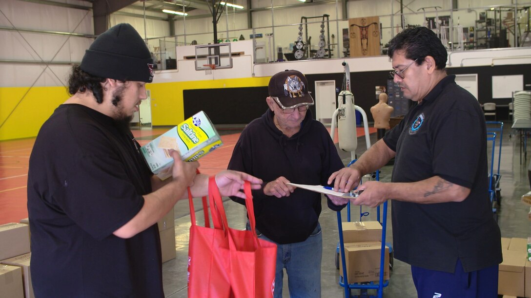 David Gibson (right) reviews a food order with participants at the Small Tribes of Western Washington food distribution center in Lakewood.