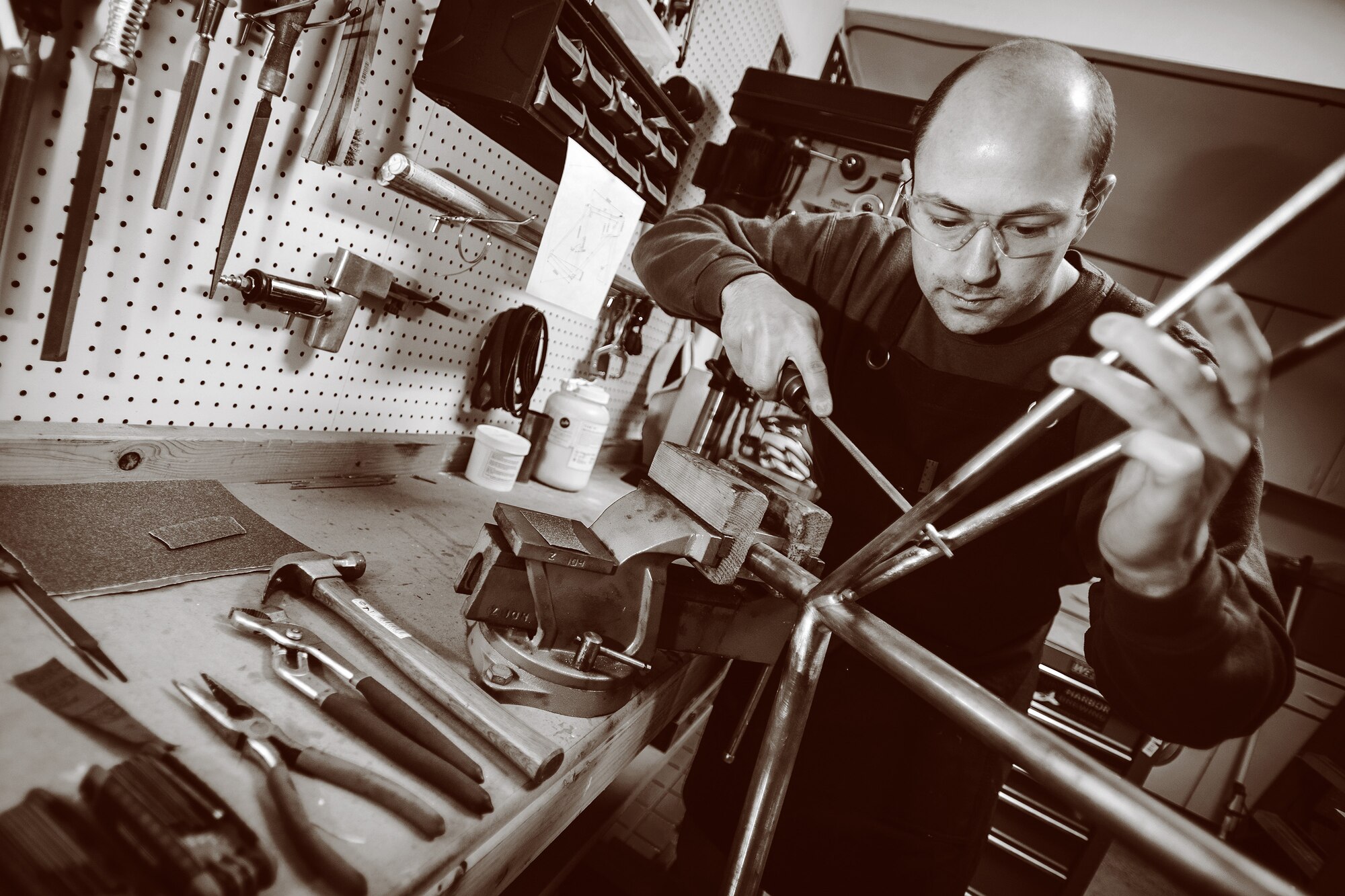 Air Force 1st Lt. Ken Cerreta files a weld on a custom-built bicycle frame. Cerreta hopes to turn his craft into a full-time job when he retires from the Air Force. (Paul Holcomb/U.S. Air Force)