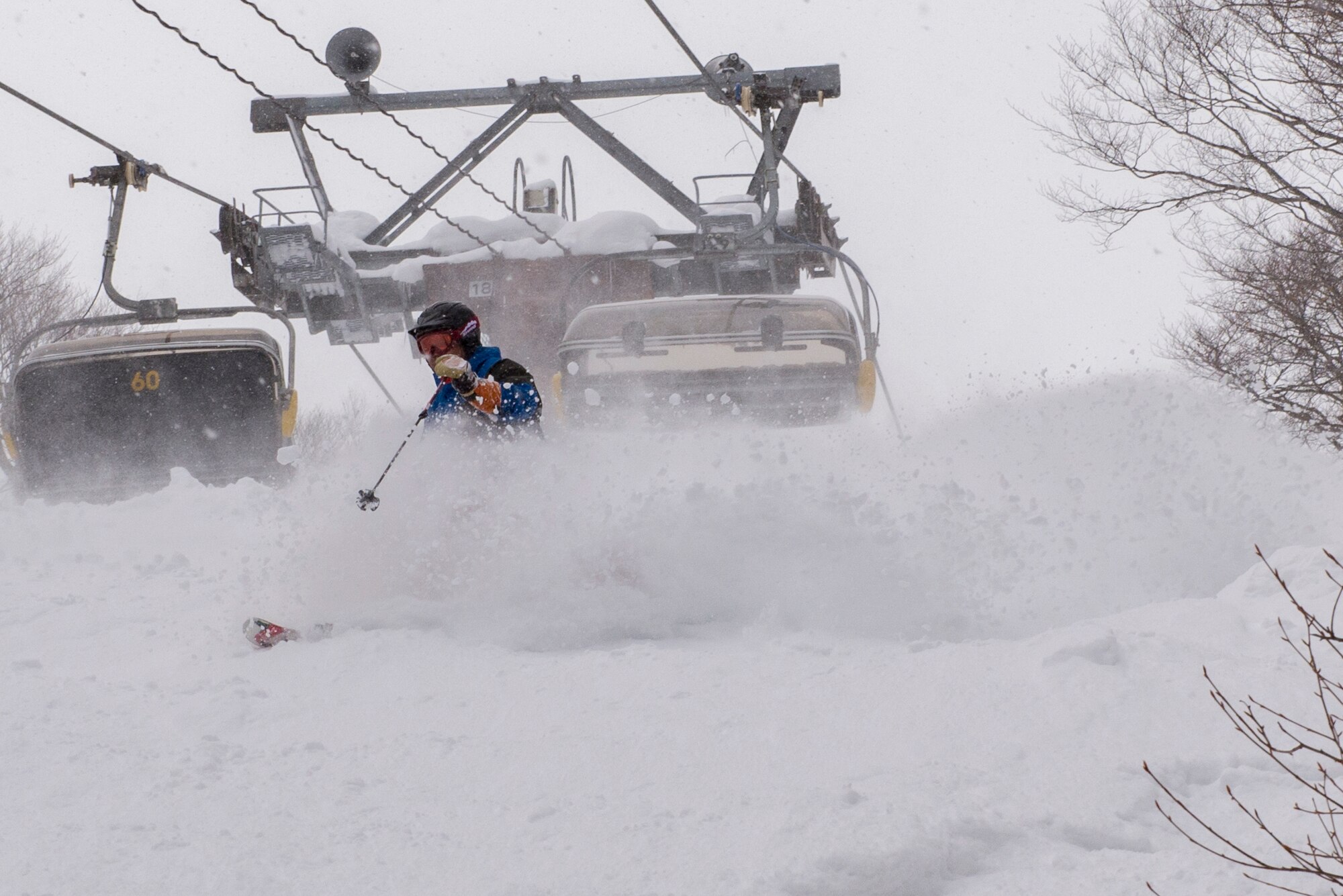 Yoshimasa Nakamura, 374th Force Support Squadron Outdoor Recreation recreation specialist, skis through fresh powder under a ski lift during a trip to Myoko-Suginohara ski resort Feb. 11, 2017, in the Niigata prefecture, Japan. Yoshi guides Outdoor Recreation customers on trips across Japan, providing guidance and knowledge on the activities and locations. (U.S. Air Force Photos by Airman 1st Class Donald Hudson)