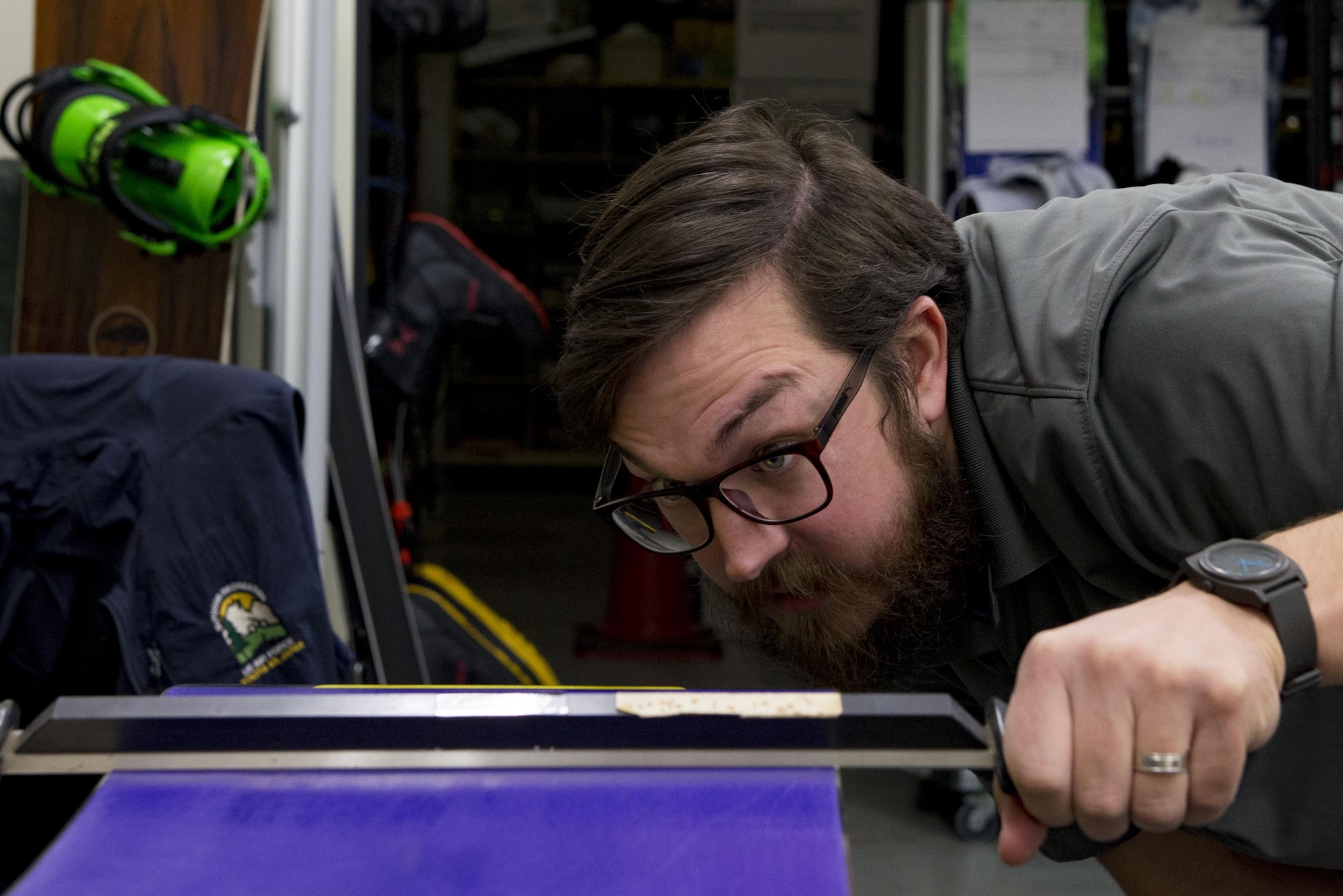 Matthew Silvia, 374th Force Support Squadron Outdoor Recreation recreation aid, checks for to ensure a snowboard base is level Feb. 16, 2017, at Yokota Air Base, Japan. Along with repair and maintenance of skis and snowboards, Outdoor Recreation offers bicycle maintenance and tune ups. (U.S. Air Force Photos by Airman 1st Class Donald Hudson)