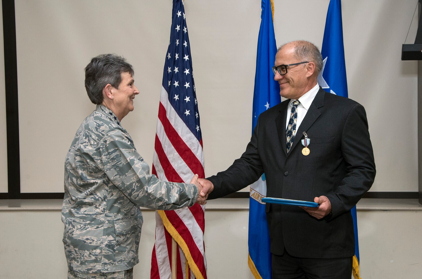 Gen. Ellen Pawlikowski congratulates Greg Gangnuss after presenting him with the Air Force Civilian Award for Valor during a Feb. 22 commander’s call at Joint Base San Antonio, Texas. 