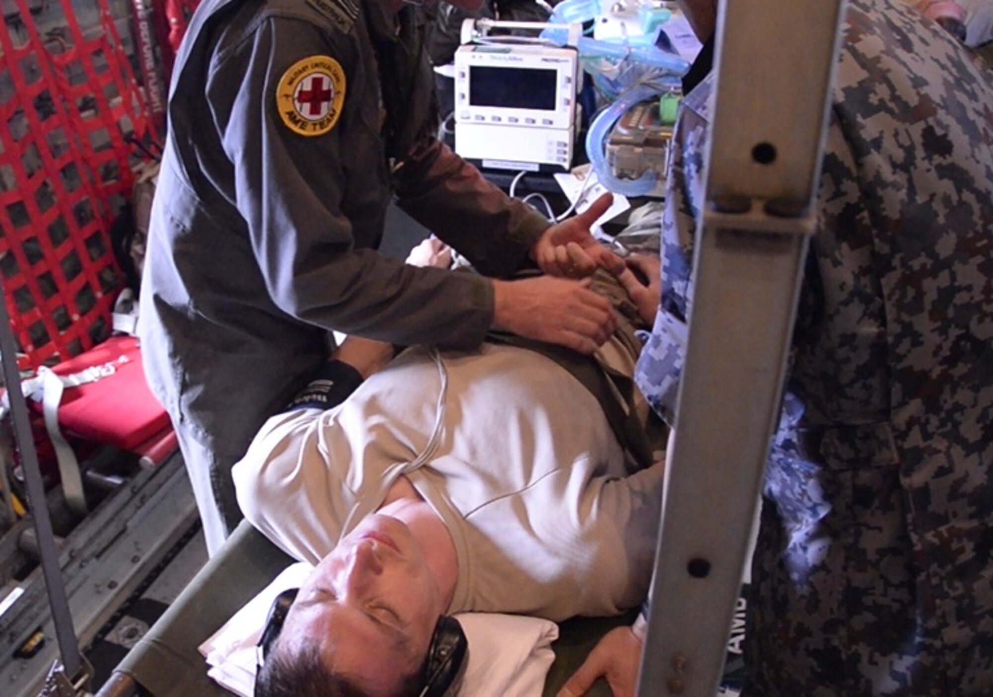 Airmen from the Japan Air Self-Defense Force and Royal Australian Air Force provide simulated treatment to a U.S. Air Force Airman aboard a JASDF C-130 Hercules as training for exercise Cope North Feb. 21, at Tinian Airfield. Airmen from each air force took turns practicing aeromedical evacuation operations aboard each other’s C-130 airframes over three days of training. (Courtesy photo)