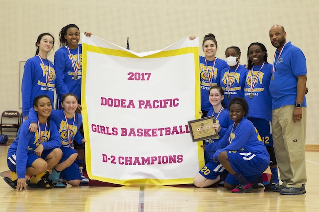 The Yokota High School ladies basketball team poses for a photo after winning the 2017 Division 2 Girls’ Basketball Tournament at the Matthew C. Perry High School gym on Marine Corps Air Station Iwakuni, Japan, Feb. 23, 2017. M.C. Perry High School hosted 11 teams from the Far East Division for the tournament. The teams endured two days of physically demanding competition for the opportunity at a championship game in a double elimination style tournament. (U.S. Marine Corps photo by Lance Cpl. Joseph Abrego)