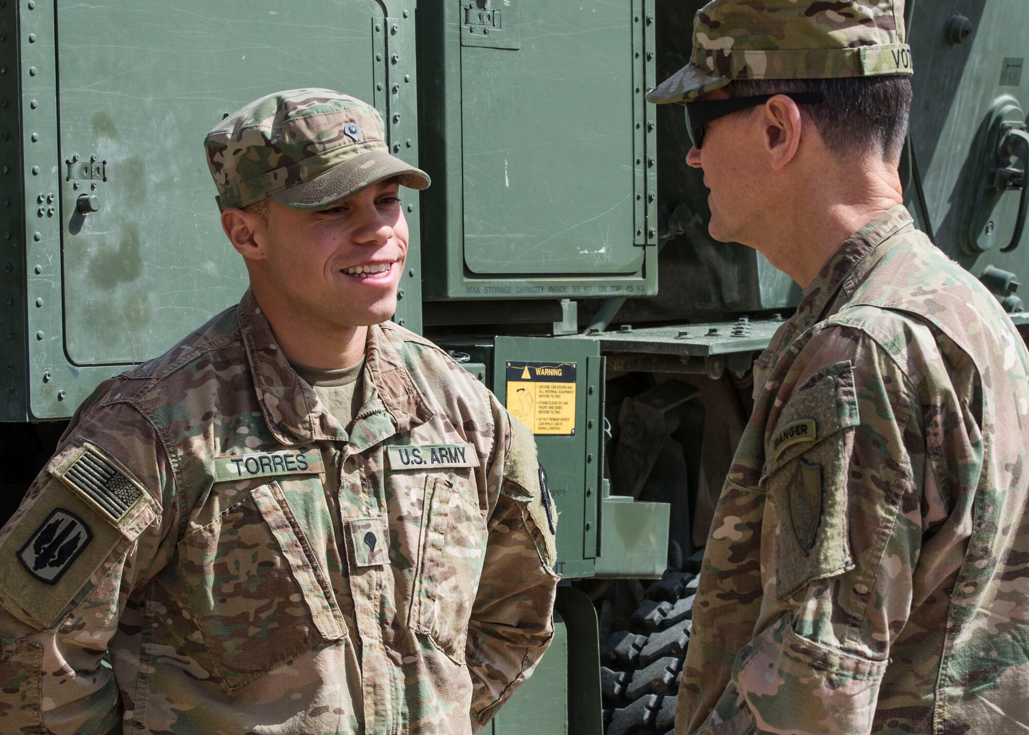 Gen. Joseph Votel, U. S. Central Command commander, speaks with Spc. Alan Torres, 3rd Battalion, 321st Field Artillery Regiment Able Battery, at an undisclosed location in Southwest Asia. Torres was coined by the general for outstanding performance. (U.S. Air Force photo/Staff Sgt. Eboni Reams)