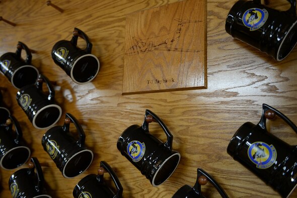 Mugs belonging to 48th Flying Training Squadron personnel hang on the wall of the 48th FTS heritage room Feb. 17, 2017, on Columbus Air Force Base, Mississippi. Mugs are hung backwards for their fallen brothers and sisters. (U.S. Air Force photo by Senior Airman John Day)