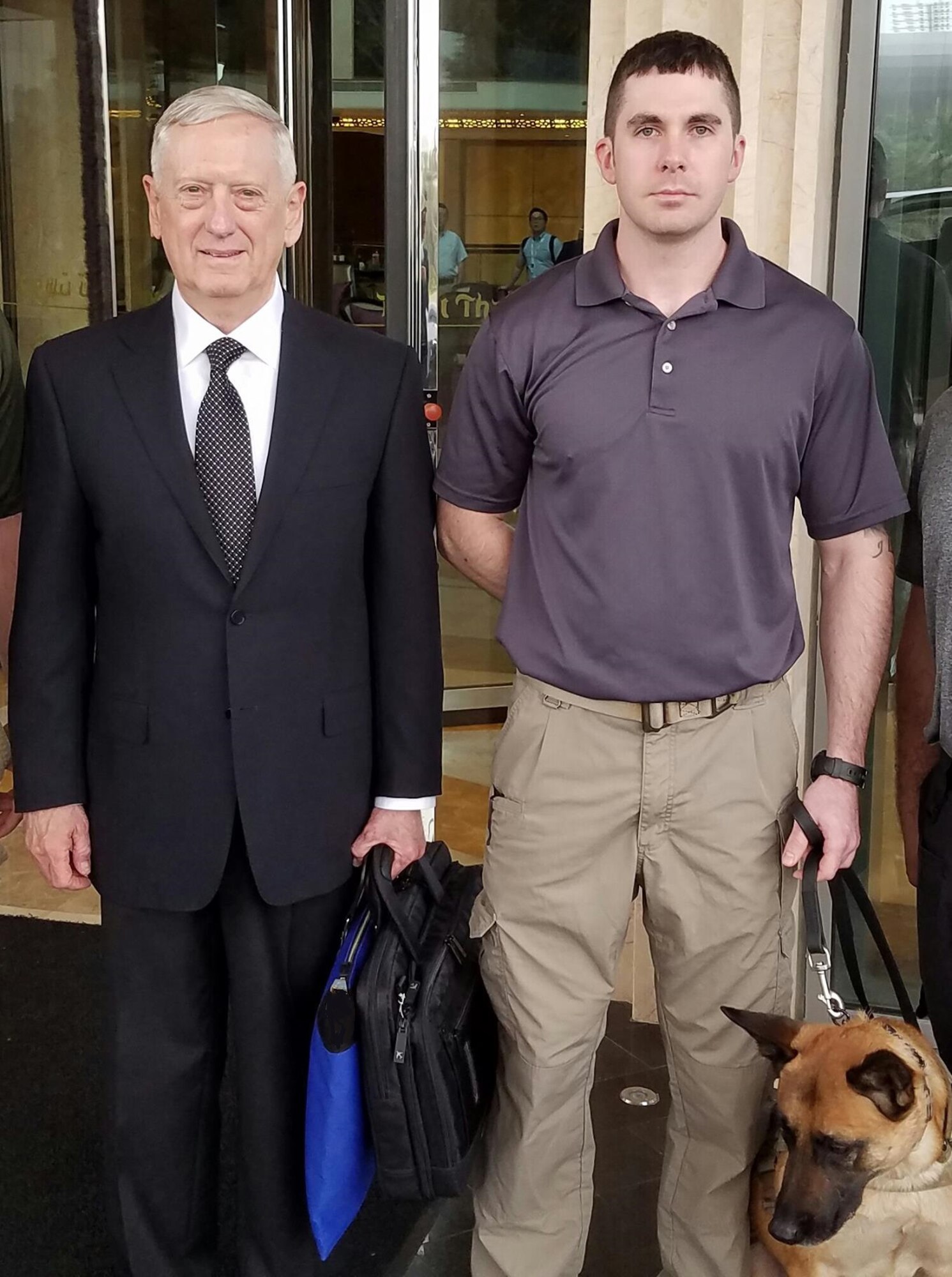 Tech. Sgt. Karl Stefanowicz, 14th Security Forces Squadron Kennel Master, and Military Working Dog Nnora pause for a photo with James Mattis, U.S. Secretary of Defense, downrange. Stefanowicz is deployed to an undisclosed location. (Courtesy photo illustration)