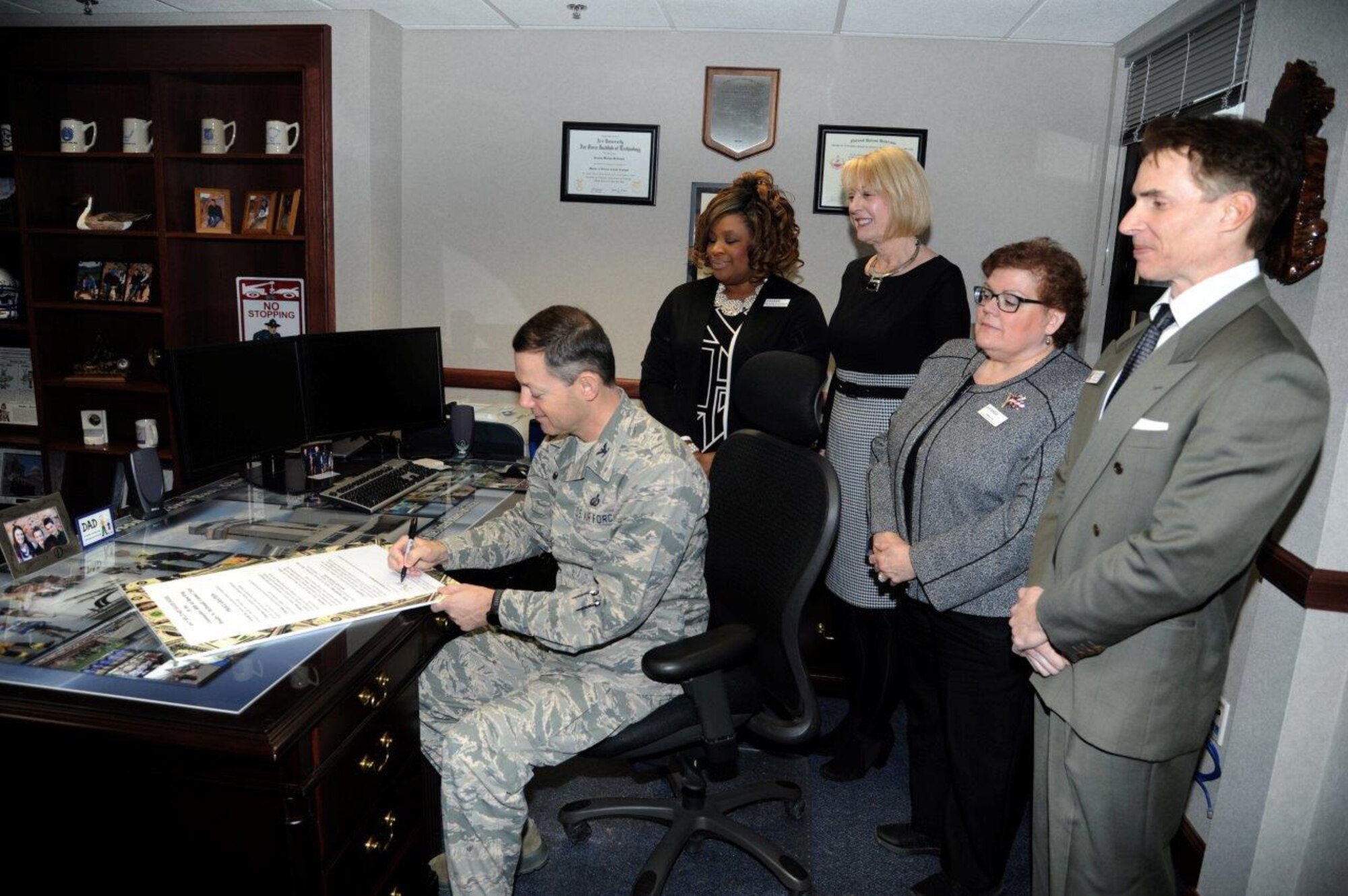 Col. Bradley McDonald, 88th Air Base Wing commander,Wright-Patterson Air Force Base, signs a proclamation Feb. 16 in honor of Military Saves Week, Feb. 27-March 4, in front of (left to right) Sharron Griffin-Gorham, community readiness specialist/ personal financial management team member; Karen Kind, flight chief,Airmen & Family Readiness Services; Dawn Ivy, community readiness specialist/personal financial management team member; and Eric Thayer, section chief,Airmen & Family Readiness Services. 