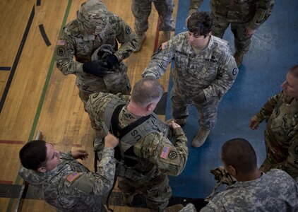 A command sergeant major puts on approximately 80 pounds of protective equipment to participate in a Military Police High Physical Demand Testing Analysis drill during a command sergeants majors and senior enlisted leader forum hosted by the 200th Military Police Command in Los Alamitos, Calif., Feb 15-18. 