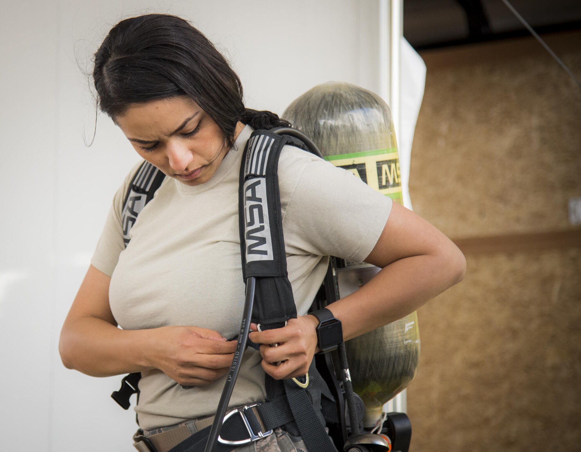 Staff Sgt. Vikki Flores, 96th Civil Engineer Group, attaches her oxygen tank to her back during the hazardous material portion of an exercise Feb. 22 at Eglin Air Force Base, Fla.  The chemical, biological, nuclear response exercise tested the procedures of emergency response, explosive ordnance disposal, disaster management and bioenvironmental agencies among others.  (U.S. Air Force photo/Samuel King Jr.)