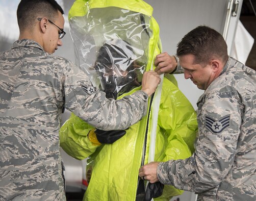 Airmen help Staff Sgt. Vikki Flores, 96th Civil Engineer Group, into her protective suit during a hazardous material portion of an exercise Feb. 22 at Eglin Air Force Base, Fla.  The chemical, biological, nuclear response exercise tested the procedures of emergency response, explosive ordnance disposal, emergency management and bioenvironmental agencies among others.  (U.S. Air Force photo/Samuel King Jr.)