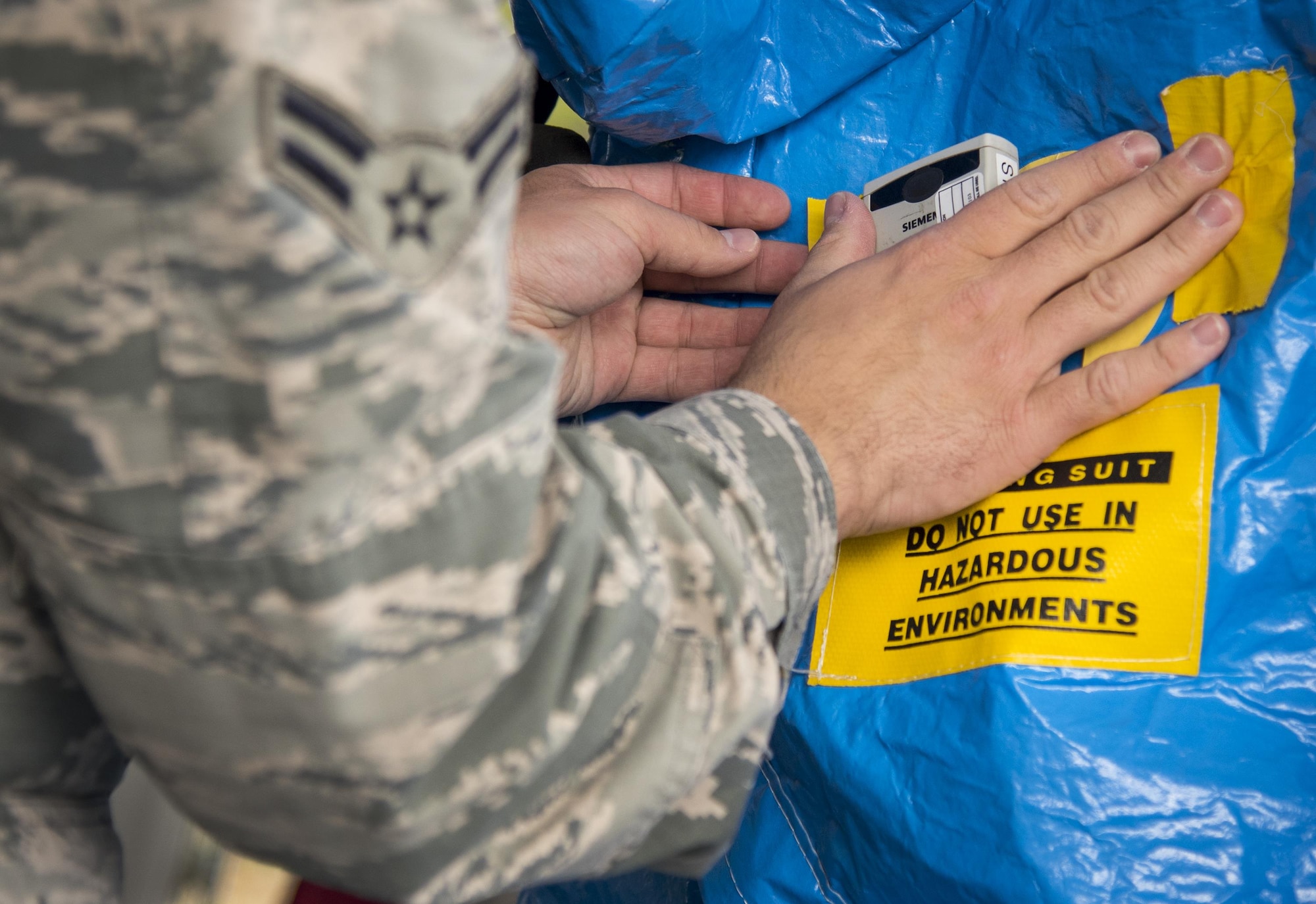 A radiation-detecting dosimeter is placed on the outside of a protective suit during a hazardous material portion of an exercise Feb. 22 at Eglin Air Force Base, Fla.  The chemical, biological, nuclear response exercise tested the procedures of emergency response, explosive ordnance disposal, disaster management and bioenvironmental agencies among others.  (U.S. Air Force photo/Samuel King Jr.)