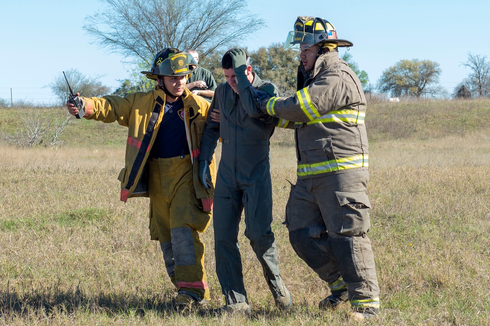 Members of the Atascosa Emergency Medical Services and the Somerset Volunteer Fire Department escort an aircrew member who was in a simulated plane crash to awaiting paramedics during a major accident response exercise (MARE) Feb. 22 in Somerset, Texas. The exercise was a joint undertaking between the 502nd Air Base Wing Inspector Generals office, Bexar County Emergency Management , the Atascosa County Emergency Medial Services and the Somerset Volunteer Firefighters Department to practice emergency response procedures in the event of an aircraft crash. As San Antonio is surrounded by smaller counties, the exercise displayed the joint efforts required to respond to off base incidents and strengthened the working relationship between Joint Base San Antonio and the surrounding communities.