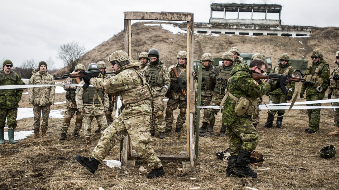 U.S. and Canadian soldiers show Ukrainian combat engineers how to clear a room while training outside.