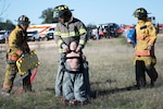 Members of the Somerset Volunteer Fire Department move a simulated crash victim from the vicinity of downed aircraft during a joint major accident response exercise Feb. 22 in Atascosa County, Texas. The exercise was a joint undertaking between the 502nd Air Base Wing Inspector General office, Bexar County Emergency Management Office, the Atascosa County Emergency Medial Services and the Somerset Volunteer Firefighters Department to practice emergency response procedures in the event of an aircraft crash.