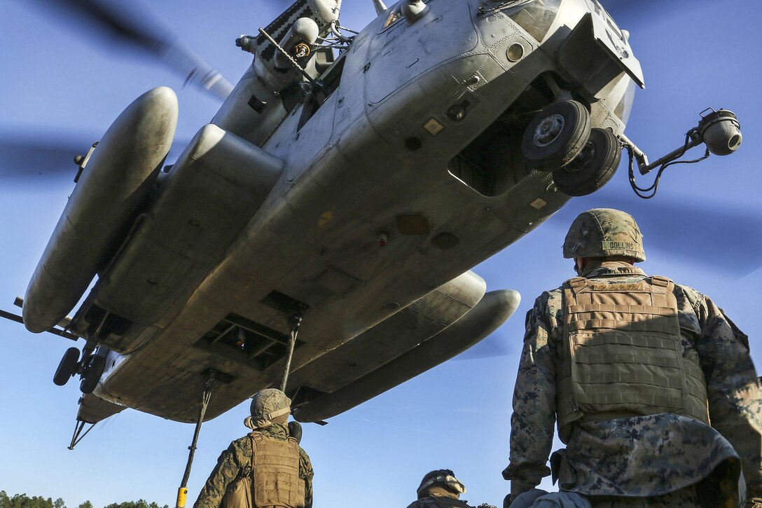 Marines watch as a CH-53 Super Stallion helicopter lifts off with a Humvee attached during helicopter support team training at Landing Zone Condor at Camp Lejeune, N.C., Feb. 16, 2017. Marine Corps photo by Lance Cpl. Tyler W. Stewart