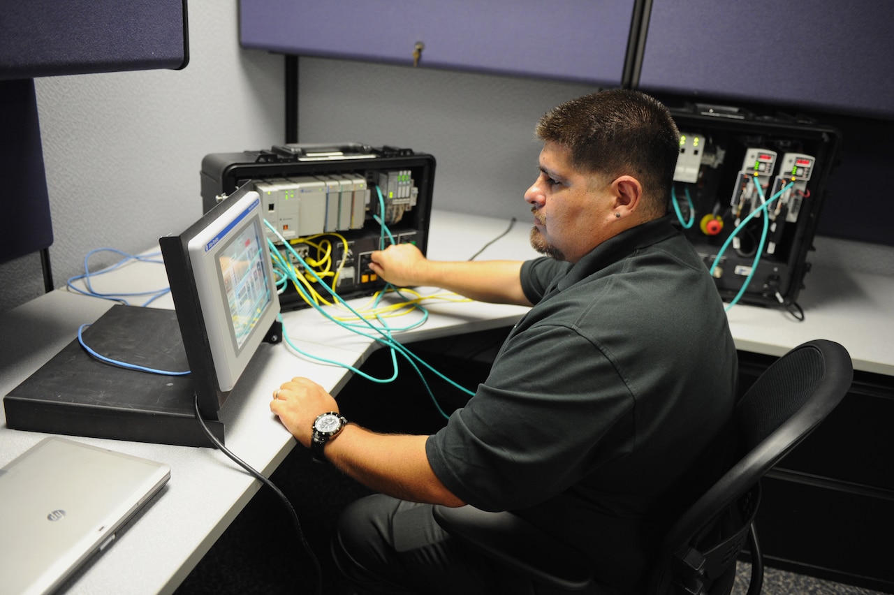 John San Miguel is pictured working with programmable logic controllers as part of the Energy Systems Technology Evaluation Program, or ESTEP, at Space and Naval Warfare Systems Command Systems Center Pacific, Nov., 20, 2013. Navy photo