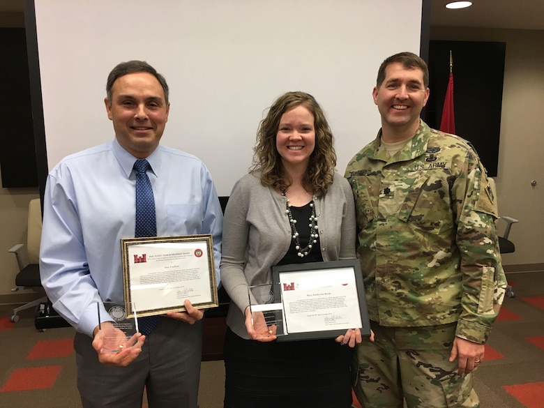 Lt. Col. Stephen Murphy (Right), U.S. Army Corps of Engineers Nashville District commander, presents achievement awards to Eric Crafton and Mary Katherine Keith during a staff meeting Feb. 16, 2017 at the Nashville District Headquarters in Nashville, Tenn. They were two of seven team members who developed a groundbreaking land exchange process that enabled the Nashville District to obtain land needed for a roller compacted concrete berm adjacent to the Center Hill Lake saddle dam at Lancaster, Tenn.