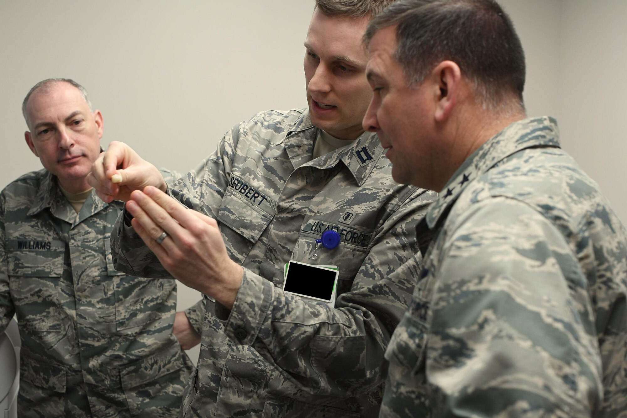 Maj. Gen. Christopher Bence, Expeditionary Center commander, and Chief Master Sgt. Larry Williams, Expeditionary Center command chief, examine the product of the CEREC MC XL machine that creates dental restoration elements as shown by Capt. Brandon Seubert, 319th Medical Operations Squadron dentist, on Grand Forks Air Force Base, N.D., Feb. 23, 2017. EC leadership visited Grand Forks AFB to gain a first-hand perspective of mission operations and Airmen readiness.(U.S. Air Force photo by Airman 1st Class Elijaih Tiggs)