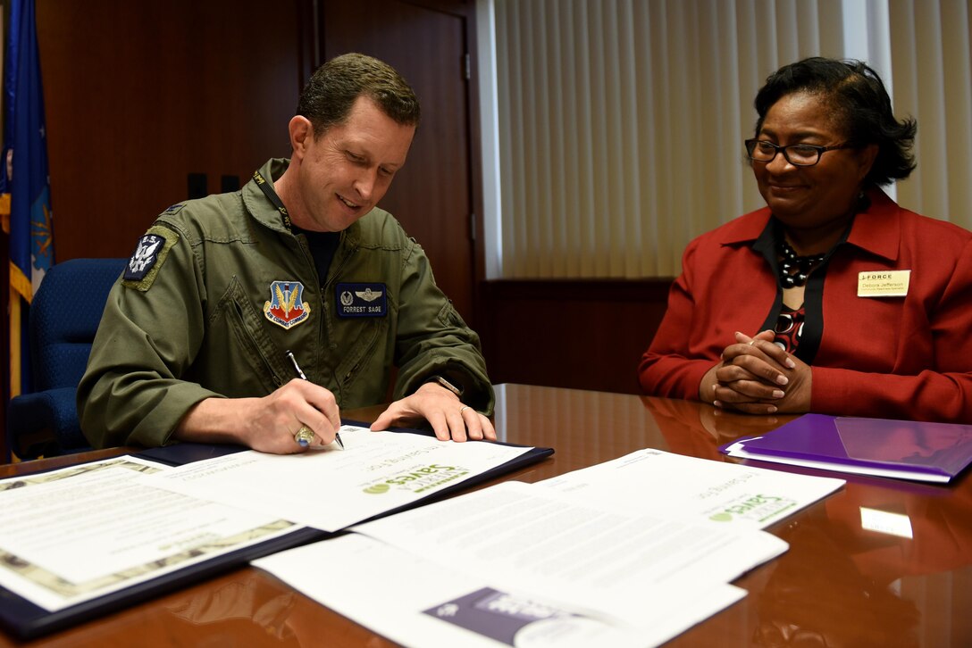 Col. Christopher Sage, 4th Fighter Wing commander, signs a proclamation recognizing Military Saves Week alongside Debora Jefferson, 4th Force Support Squadron Airman & Family Readiness Center program manager, Feb. 24, 2017, at Seymour Johnson Air Force Base, North Carolina. Various financial workshops are scheduled to run until March 3, 2017. For more information call A&FRC at 919-722-1123. (U.S. Air Force photo by Airman 1st Class Victoria Boyton)