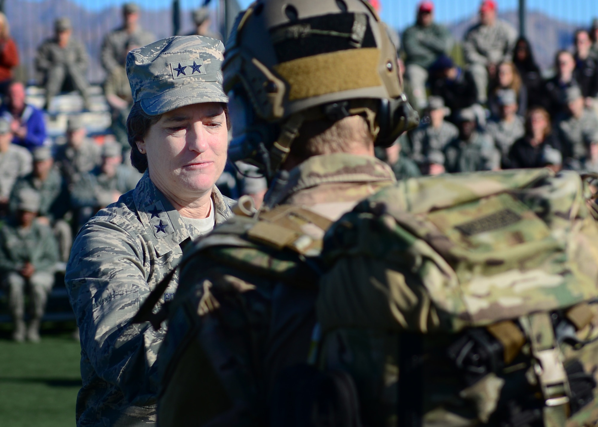 U.S. Air Force Maj. Gen. Peggy Poore, Air Force Personnel Center commander, accepts the Care Beyond Duty flag and thanks the U.S. Air Force pararescueman presenter during the 2017 Air Force Warrior Game Trials opening ceremony Feb. 24, 2017 at Nellis Air Force Base, Nev. Under Poore's leadership, the Wounded Warrior Program advocated for over $24 million in unpaid entitlements and benefits that will span a lifetime for warriors and their families. (U.S. Air Force photo by Senior Airman Chip Pons) 