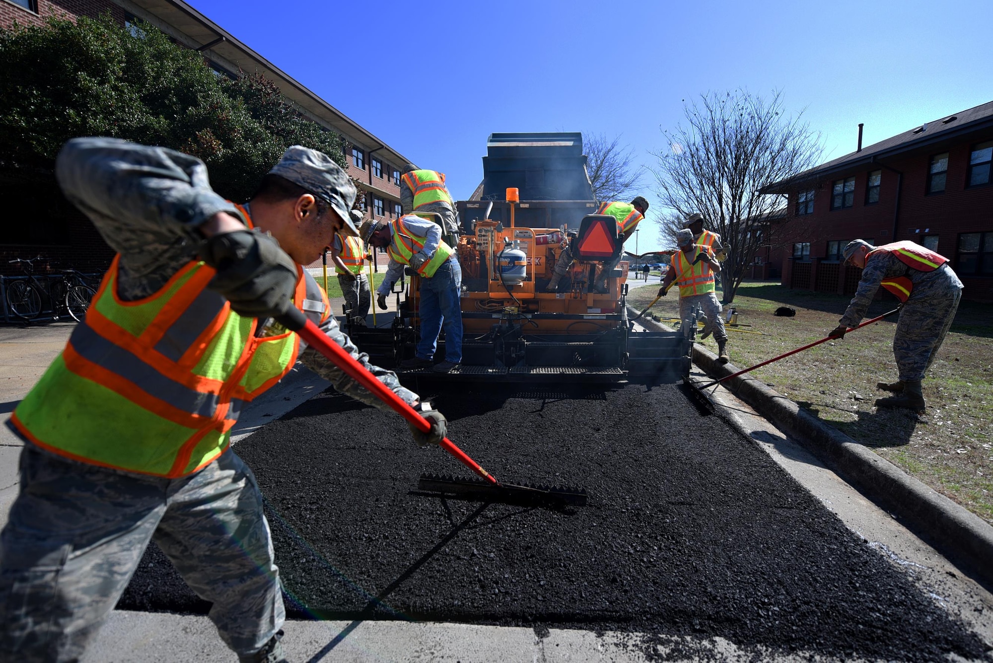 U.S. Air Force Senior Airman Allen Arceo, 19th Civil Engineer Squadron pavement and heavy equipment craftsman, uses a lute tool to spread the asphalt evenly Jan. 7, 2017 at Little Rock Air Force Base, Ark. The lute tool corrects any imperfections left behind by the paver and helps form the edges on the pavement. (U.S. Air Force photo by Airman 1st Class Kevin Sommer Giron)