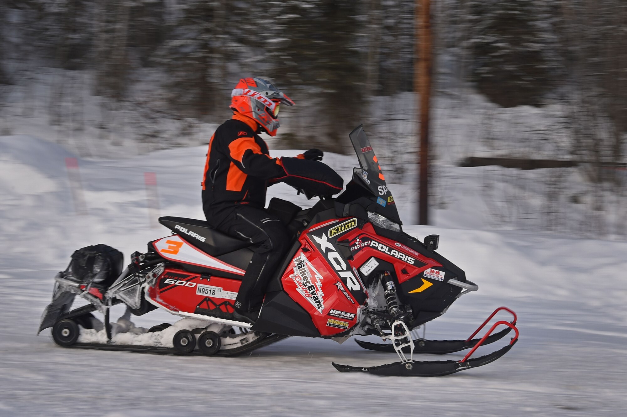 A snowmobile racer rides through trails at Joint Base Elmendorf-Richardson, Alaska, during the Iron Dog race Feb. 18, 2017. Military personnel and families gathered to high-five racers as they passed by Otter Lake. 