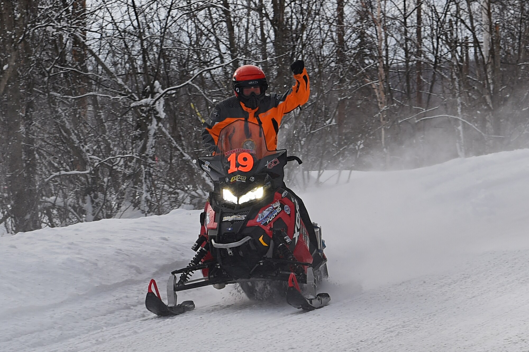 A snowmobile racer passes fans while riding through trails at Joint Base Elmendorf-Richardson, Alaska, during the Iron Dog race Feb. 18, 2017.The Iron Dog race has a course distance of 2,000 miles making it the world’s longest snowmobile race. 