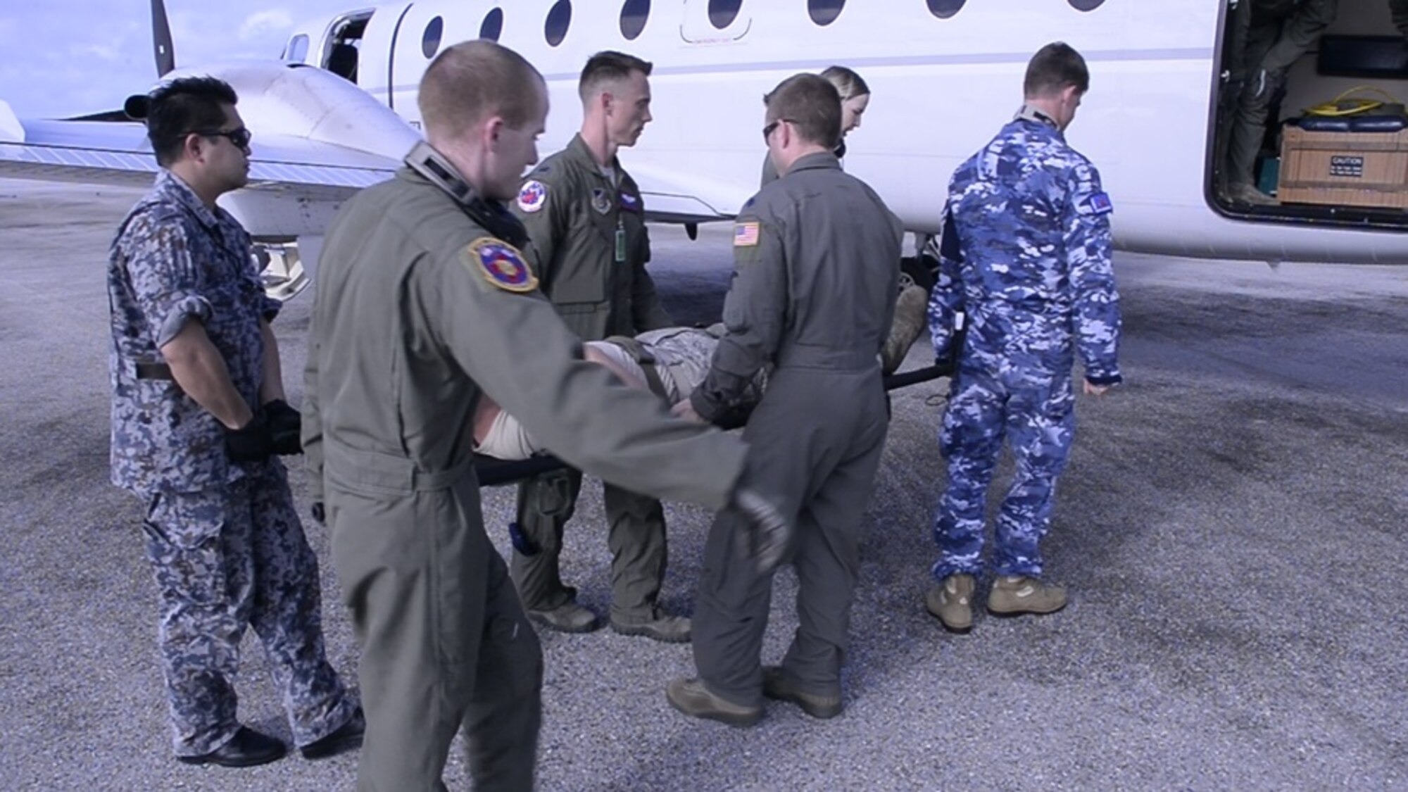 Aeromedical evacuation Airmen from the U.S., Japanese, and Australian air forces transport a simulated patient to a U.S. Air Force C-12 Huron as part of annual exercise Cope North at Tinian Air Field, Mariana Islands, Feb. 21, 2017. Aeromedical evacuation training was conducted on the Huron to familiarize Airmen with patient care on a new airframe. Cope North is a long-standing exercise designed to enhance multilateral air operations between the partnered militaries, bringing together more than 2,700 U.S. Airmen, Sailors and Marines who are training alongside approximately 600 combined Japan Air Self-Defense Force and Royal Australian Air Force participants. (Courtesy photo)