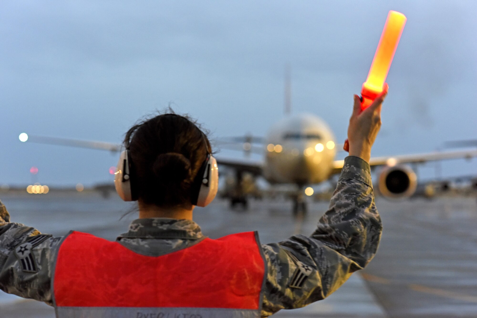 U.S. Air Force Senior Airman Sylvia Feigum, a combat oriented supply organization journeyman with the 8th Expeditionary Air Mobility Squadron, marshals in a Boeing 777-200 at Al Udeid Air Base, Qatar, Feb. 16, 2017. Feigum’s primary role as a COSO is to coordinate supply requests for C-17 Globemaster III aircraft maintenance, but because of her additional duties here she also has the opportunity to guide aircraft to their parking spot. This particular aircraft happened to be carrying her husband, U.S. Air Force Senior Airman Matthew Feigum, a combat crew communications journeyman with the 816th Expeditionary Air Lift Squadron. (U.S. Air Force photo by Senior Airman Cynthia A. Innocenti)