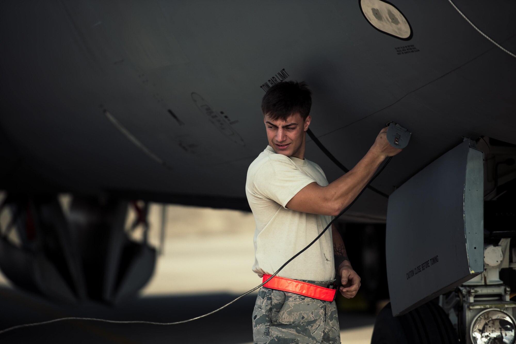 U.S. Air Force Airman 1st Class Bradley Romaker, 909th Aircraft Maintenance Unit aerospace propulsion journeyman, plugs a communications line into a KC-135R Stratotanker during maintenance Feb. 16, 2017, at Kadena Air Base, Japan. Maintainers on the flightline use the communications line to communicate from outside to inside the aircraft. (U.S. Air Force photo by Senior Airman Omari Bernard/Released)