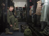 U.S. Air Force Maj. Richard Smeeding, the 35th Fighter Wing Pacific Air Force F-16 Demonstration Team pilot, puts on his boot at Misawa Air Base, Japan, Feb. 8, 2017. The aircrew flight equipment personnel fits each pilot's G-suit to their size and ensures all equipment is serviceable before their departure. (U.S. Air Force photo by Airman 1st Class Sadie Colbert)