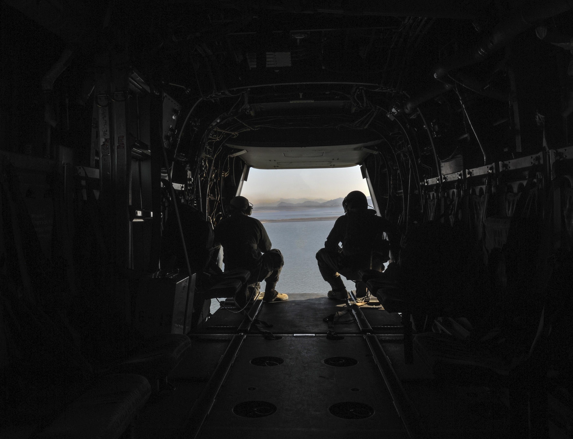 U.S. Air Force Senior Airman Michael Hunsaker, 8th Fighter Wing Public Affairs photojournalist, Kunsan Air Base, Republic of Korea, left, and Marine Cpl. Tyler Gartin, Marine Medium Tiltrotor Squadron (VMM) 265, MV-22 Osprey crew chief, surveys the area for other aircraft while flying over Kunsan Air Base, Republic of Korea, Feb. 2, 2017. Gartin provided eyes to the pilots who could not see directly out the rear of the aircraft and Hunsaker photographed the mission. (U.S. Air Force photo by Senior Airman Colville R. McFee)