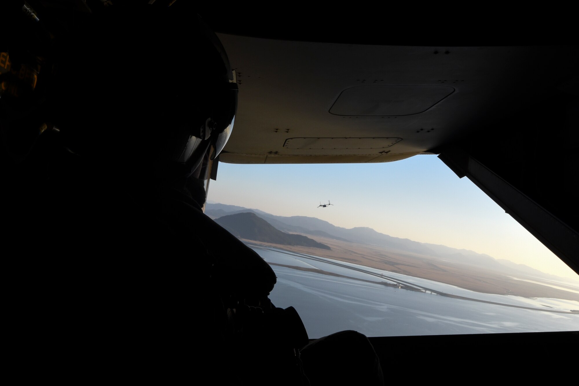 U.S. Marine Corps Cpl. Tyler Gartin, an MV-22 Osprey tiltrotor crew chief assigned to Marine Medium Tiltrotor Squadron (VMM) 265, monitors the location of a MV-22 Osprey during flight over Kunsan Air Base, Republic of Korea, Feb. 2, 2017. Gartin provided visual aid to the pilot who cannot see out of the rear of the aircraft. . (U.S. Air Force photo by Senior Airman Michael Hunsaker)
