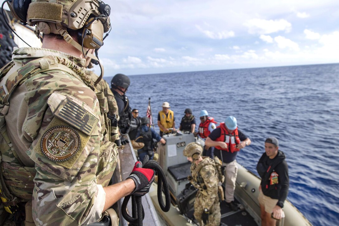 Sailors, Coast Guardsmen and Nauru law enforcement officials disembark from a foreign-flagged fishing vessel after an Oceania Maritime Security Initiative boarding mission in the Pacific Ocean, Feb. 14, 2017. The sailors are assigned to the USS Michael Murphy and the Coast Guardsmen are assigned to Law Enforcement Detachment 103.  Navy photo by Petty Officer 3rd Class Danny Kelley