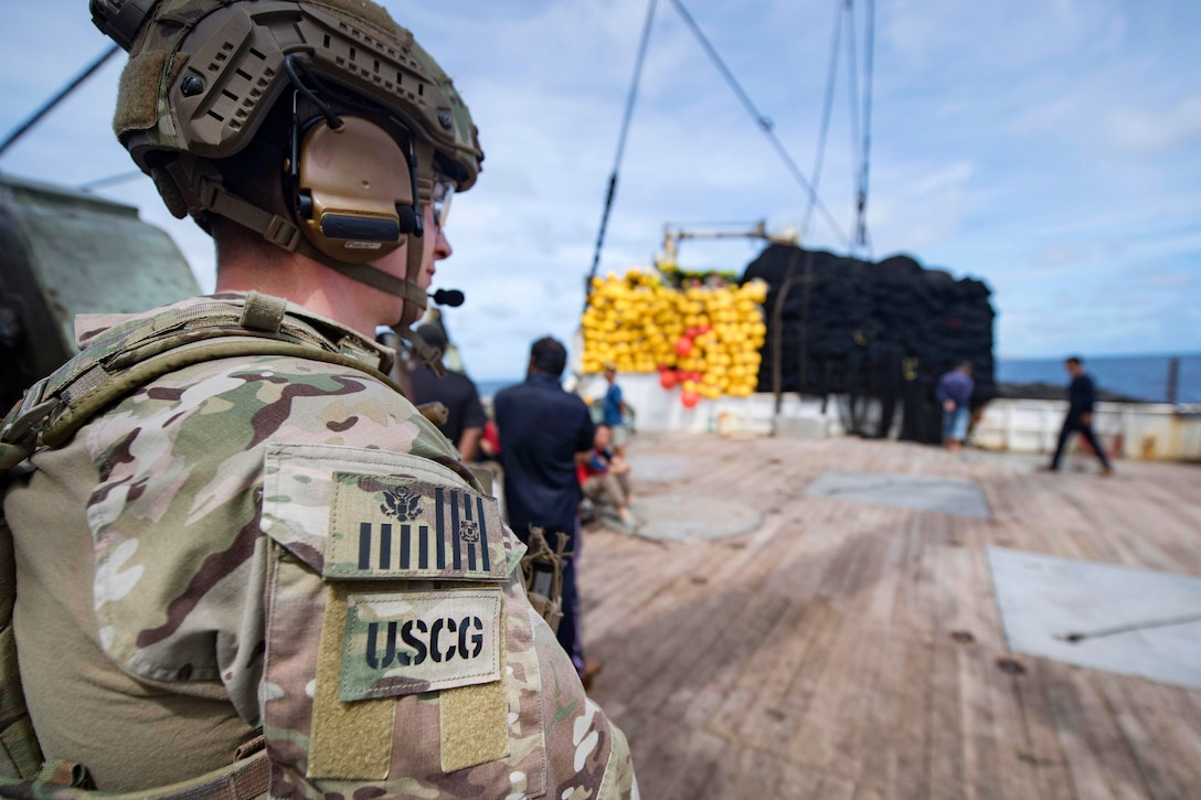 A Coast Guardsman stands watch on the fishing deck of a foreign-flagged fishing vessel during an Oceania Maritime Security Initiative boarding mission in the Pacific Ocean, Feb. 15, 2017. Navy photo by Petty Officer 3rd Class Danny Kelley