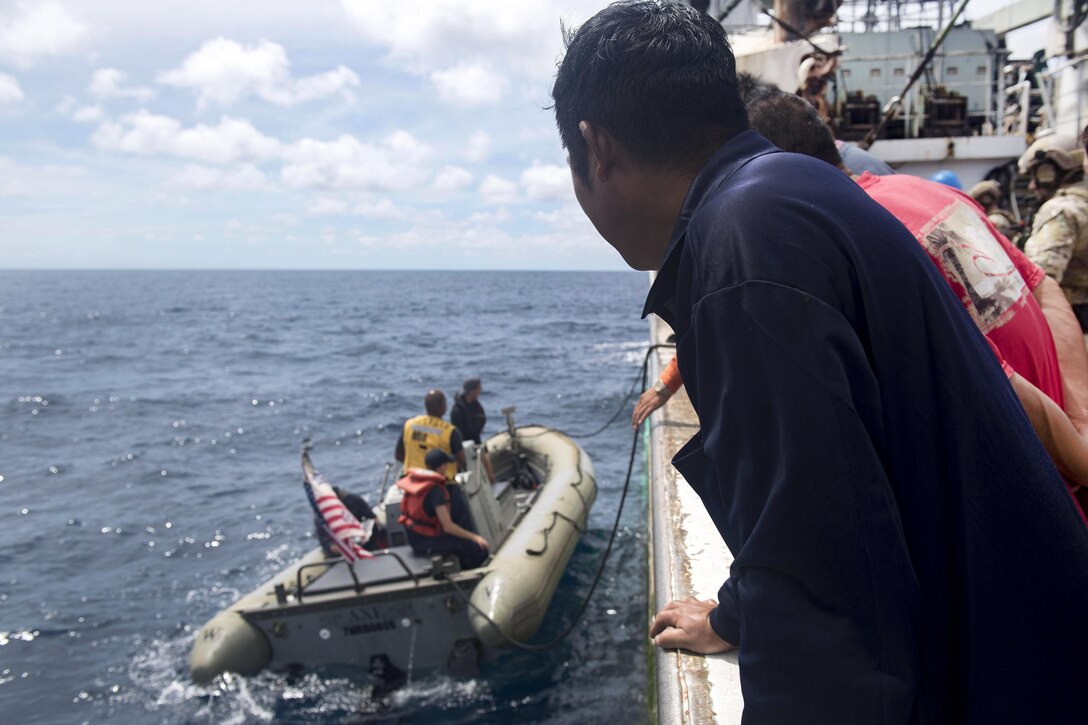The crew of a foreign-flagged fishing vessel observes a rigid hull inflatable boat from the USS Michael Murphy come alongside to disembark sailors and Coast Guardsmen after conducting an Oceania Maritime Security Initiative boarding mission in the Pacific Ocean, Feb. 15, 2017. Navy photo by Petty Officer 3rd Class Danny Kelley